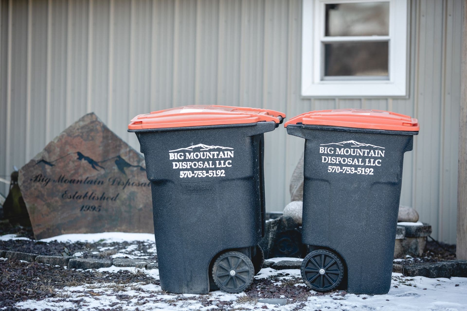 Big Mountain Disposal driver loading a roll-off dumpster onto the truck in Central PA